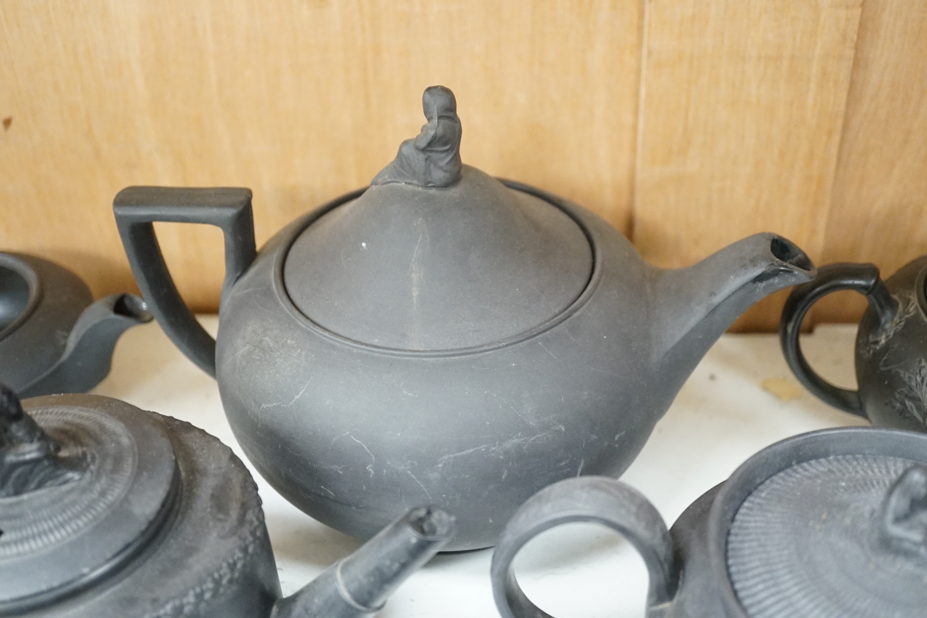 A collection of Wedgwood and other black basalt teapots and tea wares, 19th/early 20th century, tallest teapot 17cms high